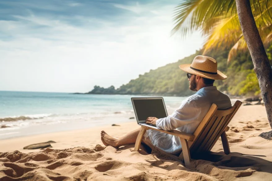 Ein Bild eines Menschen, der entspannt am Laptop am Strand arbeitet, symbolisierend, dass man überall Geld verdienen kann.